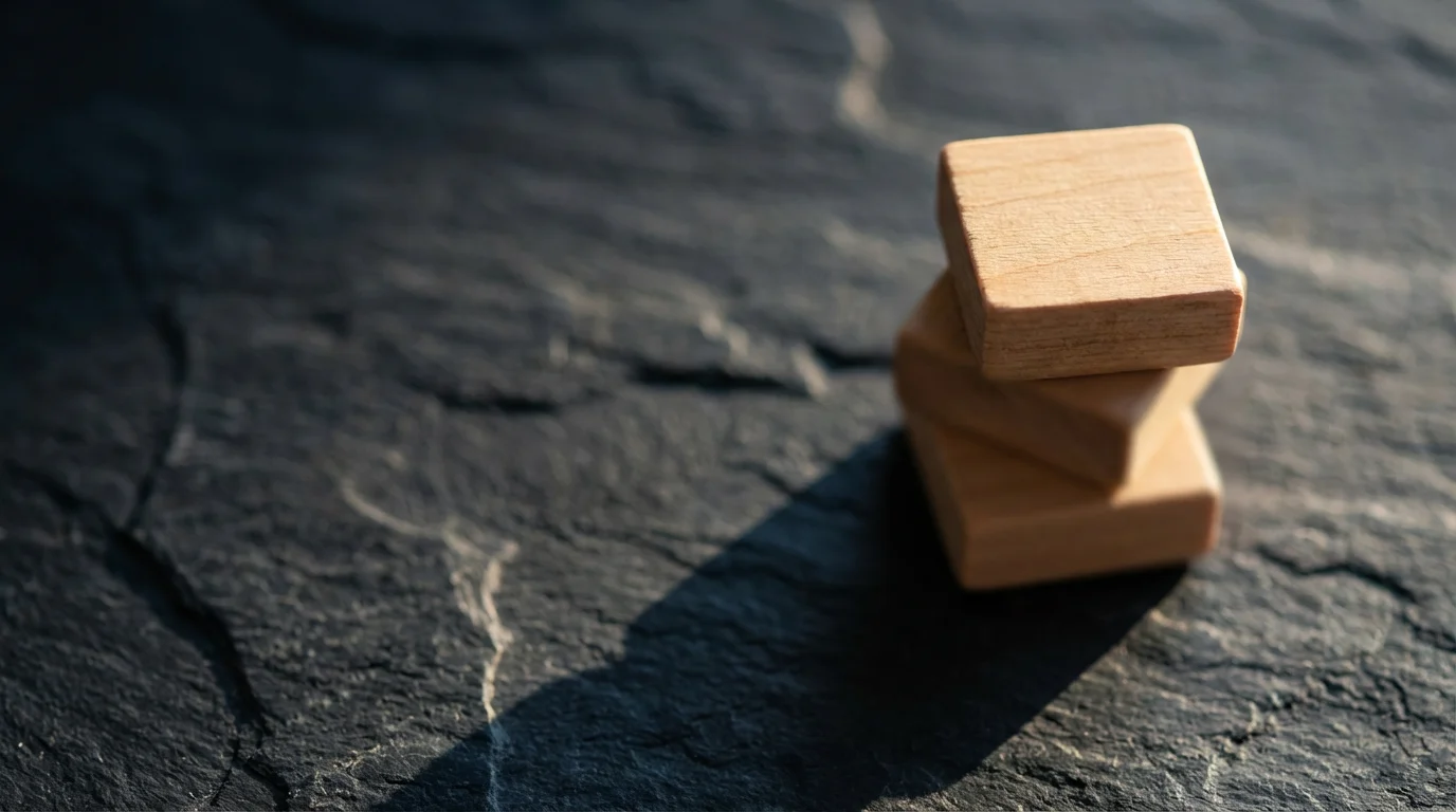 Close-up macro photo of three stacked minimalist wooden blocks, symbolizing quarterly focus themes.