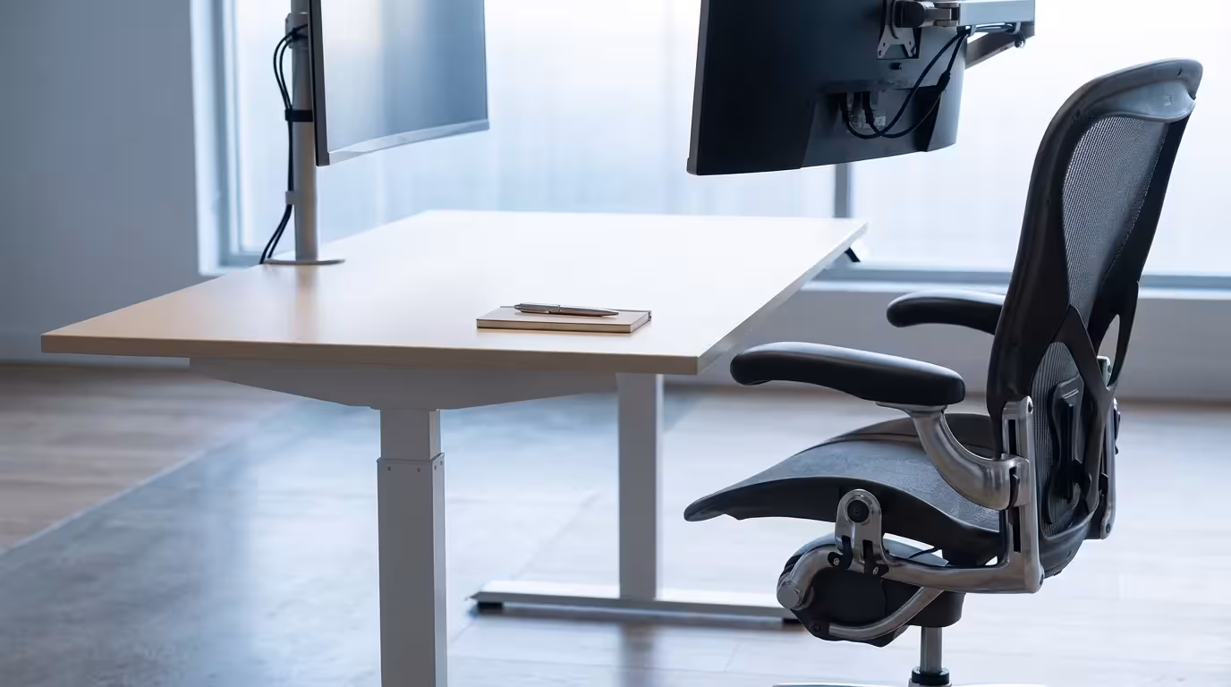 Low angle view of ergonomic desk setup with mesh chair and adjustable monitor arm