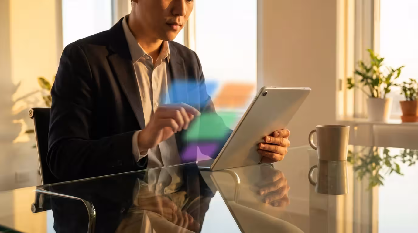 Person using a tablet with a swiping motion to organize files during golden hour.