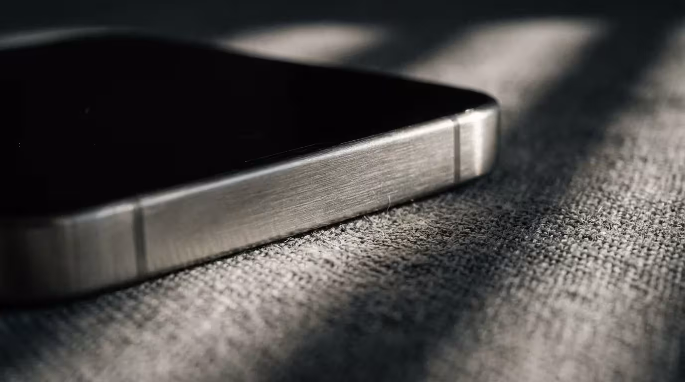Smartphone lying face down on textured fabric in moody afternoon lighting showing silence.
